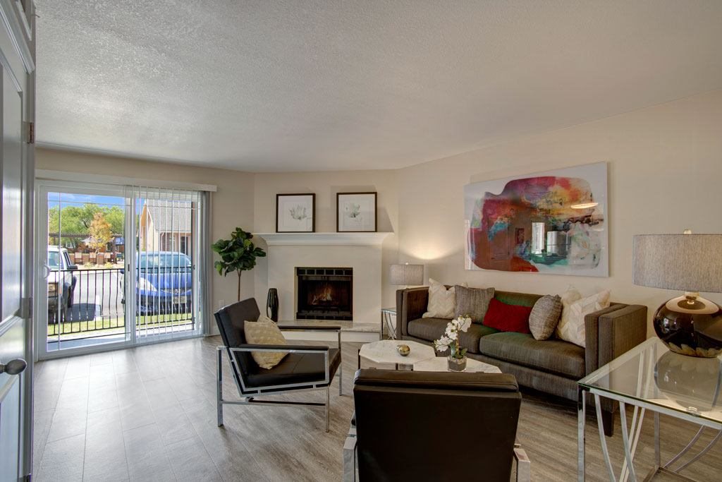 A living room with a fireplace, couch, and chairs.